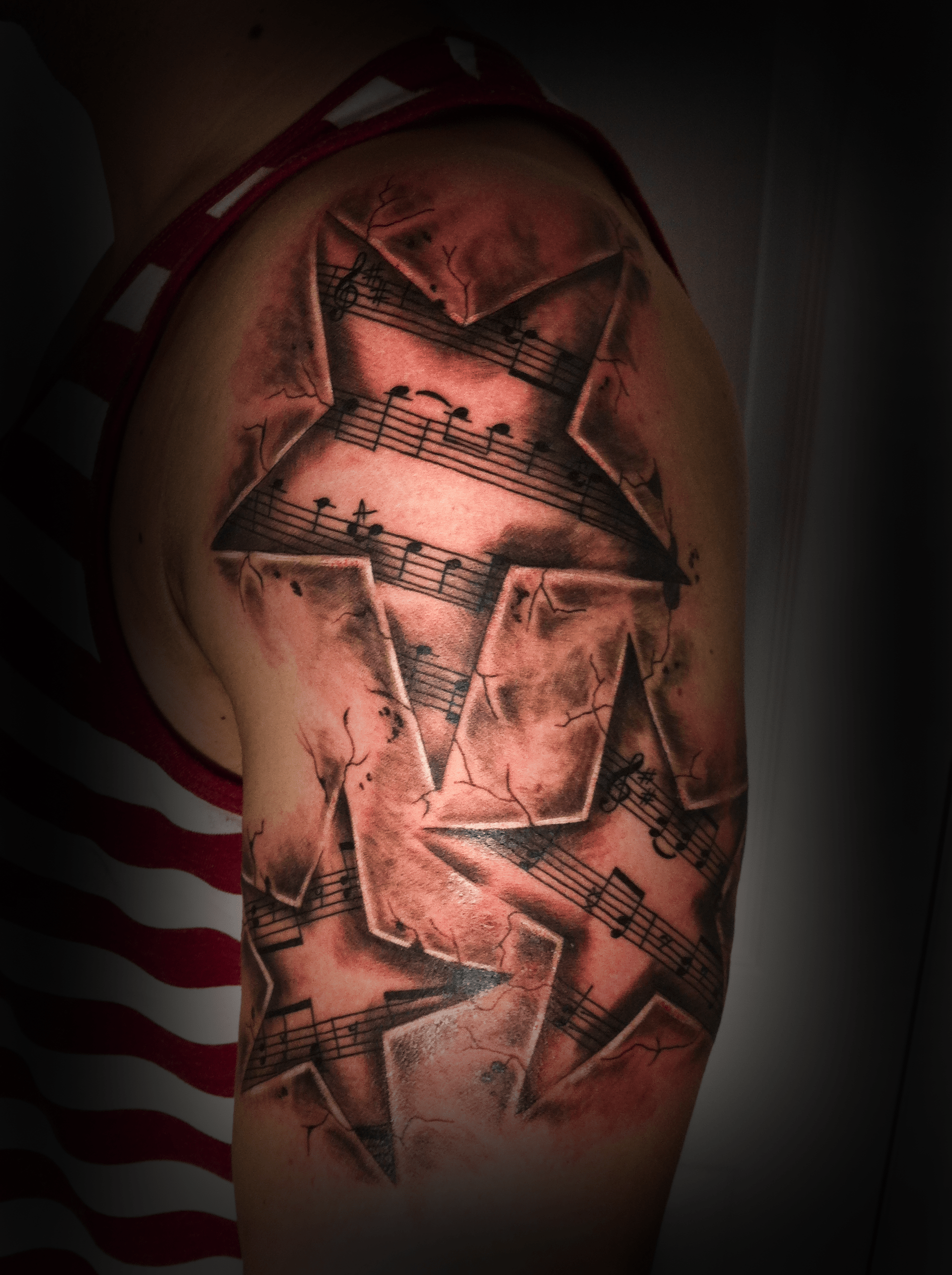 An image of a custom tattoo from Kevin Younger's Lucky Cat Tattoo Parlour: a design featuring stars filled with musical notes