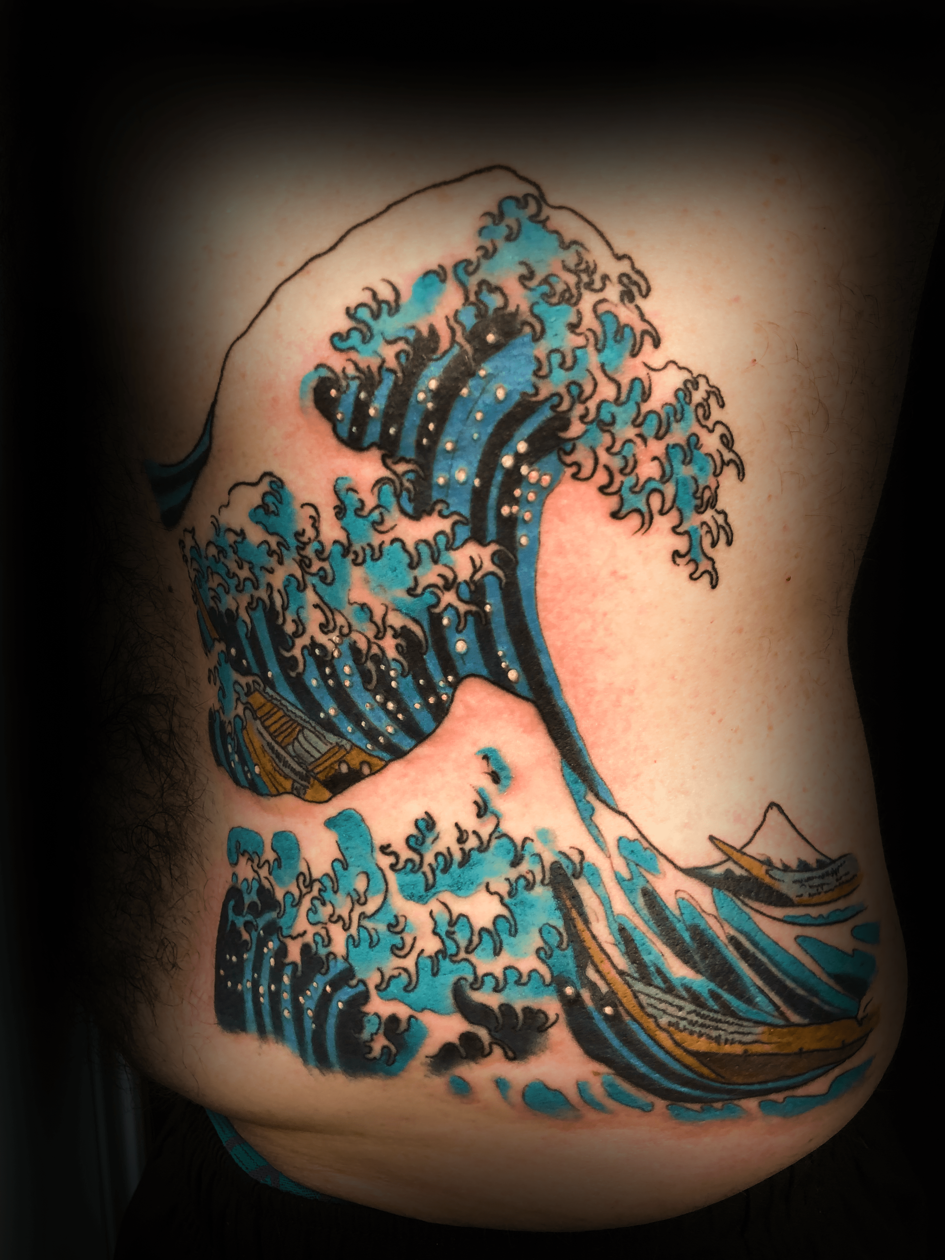An image of a custom tattoo from Kevin Younger's Lucky Cat Tattoo Parlour: a design featuring Japanese style waves