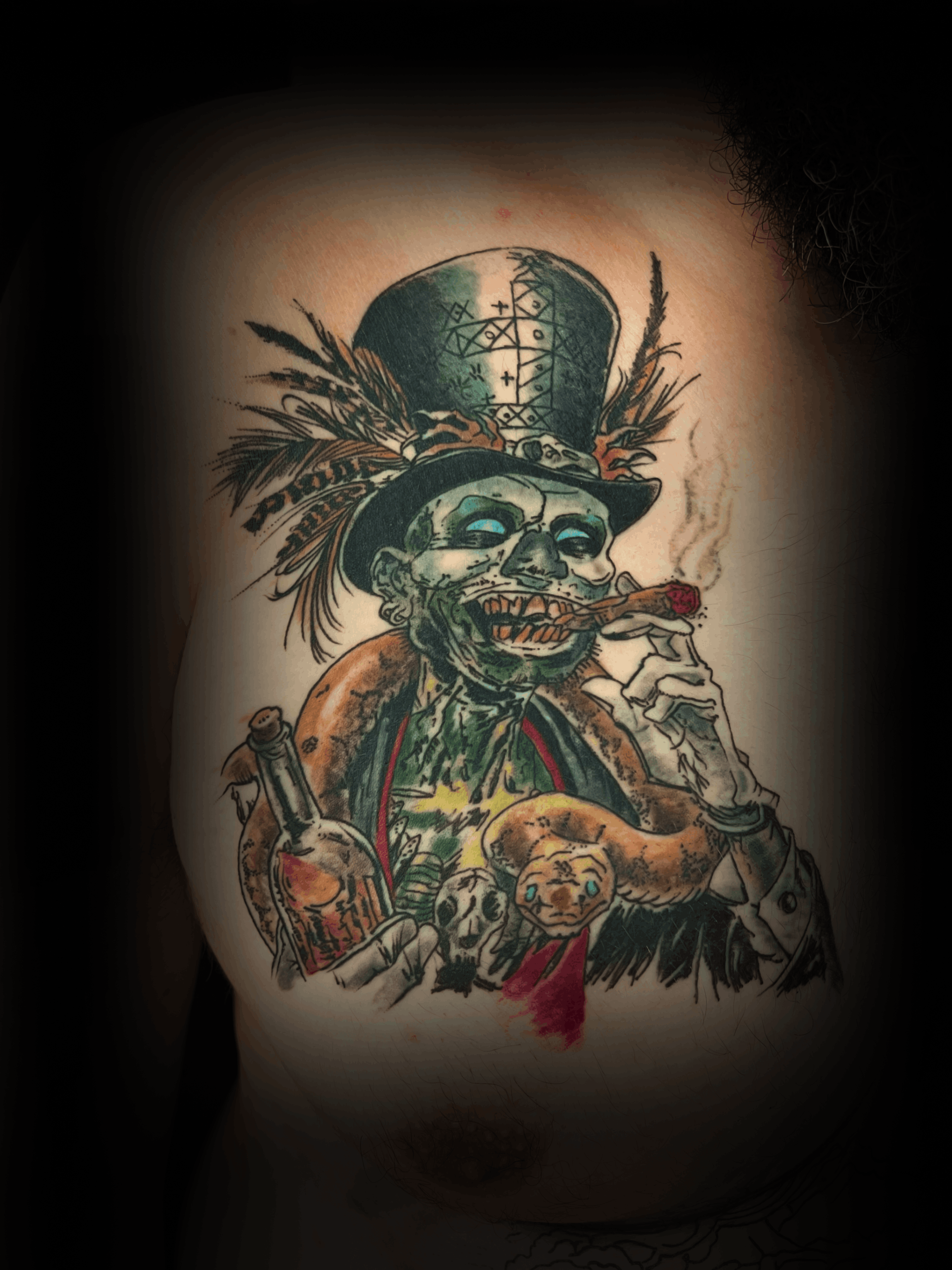 An image of a custom tattoo from Kevin Younger's Lucky Cat Tattoo Parlour: a design featuring a scary character smoking with a snake