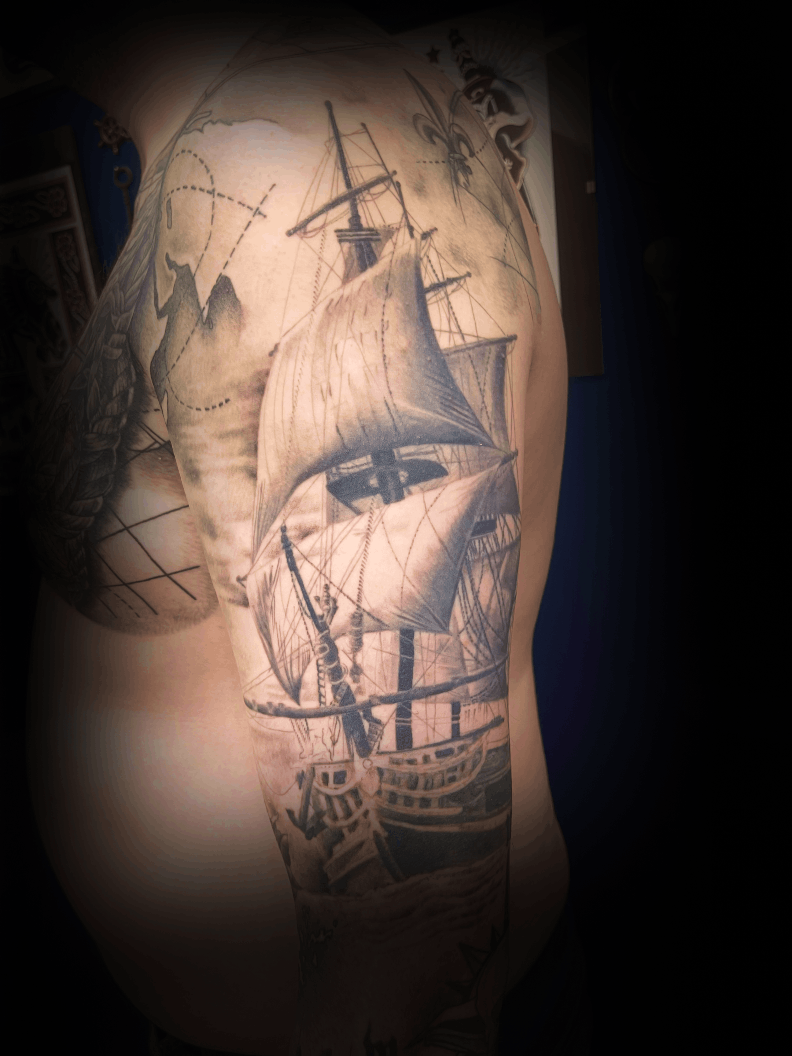 An image of a custom tattoo from Kevin Younger's Lucky Cat Tattoo Parlour: a design featuring a black and grey old sailing ship