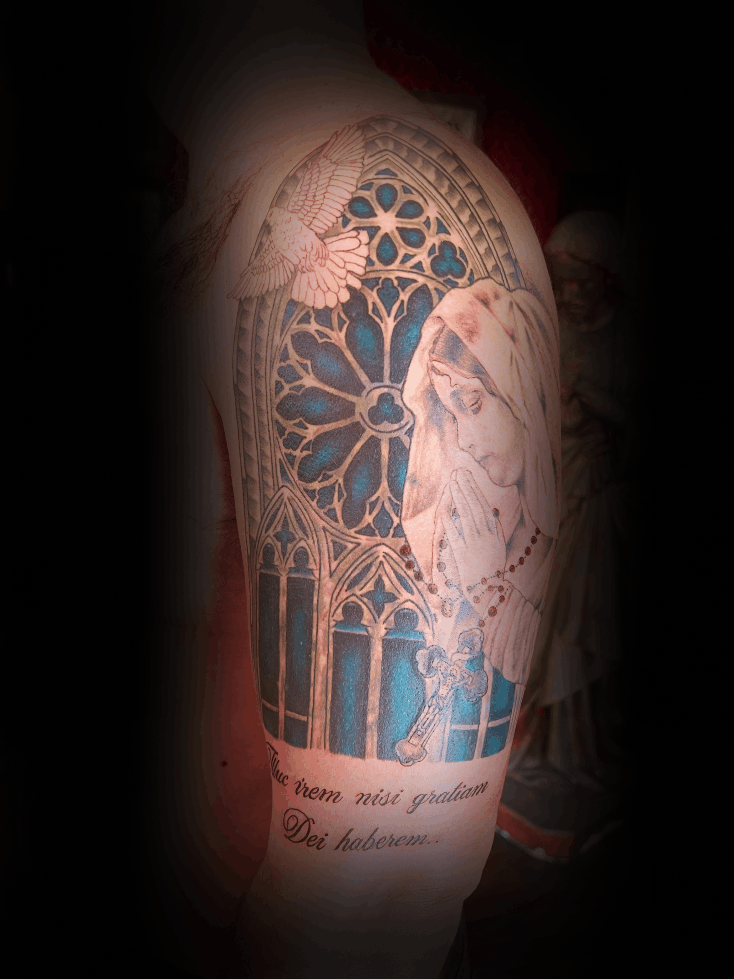 An image of a custom tattoo from Kevin Younger's Lucky Cat Tattoo Parlour: a design featuring church windows and a woman praying