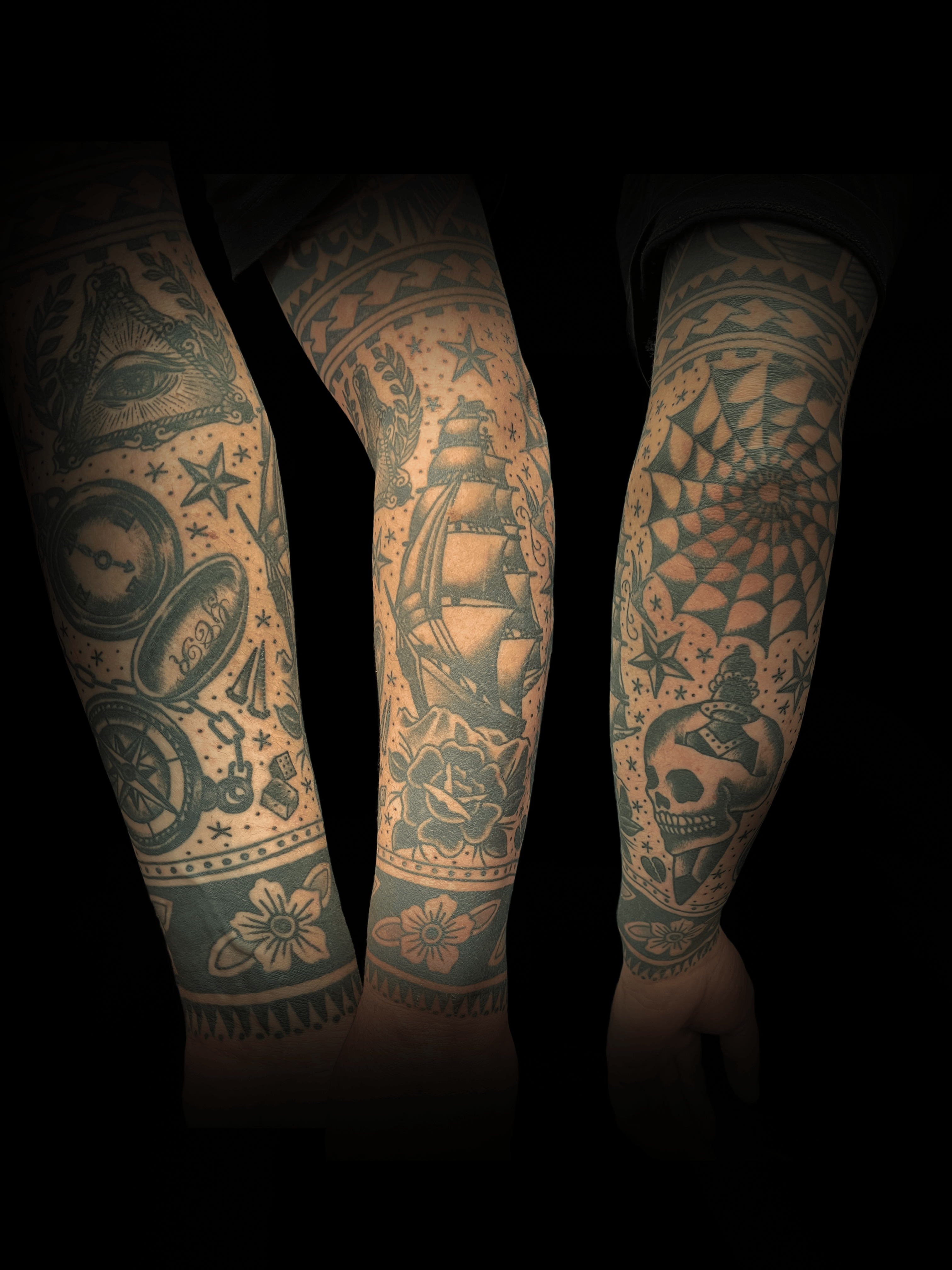 An image of a custom tattoo from Kevin Younger's Lucky Cat Tattoo Parlour: a design featuring a black and grey traditional sleeve with stars, spiders web, and skulls