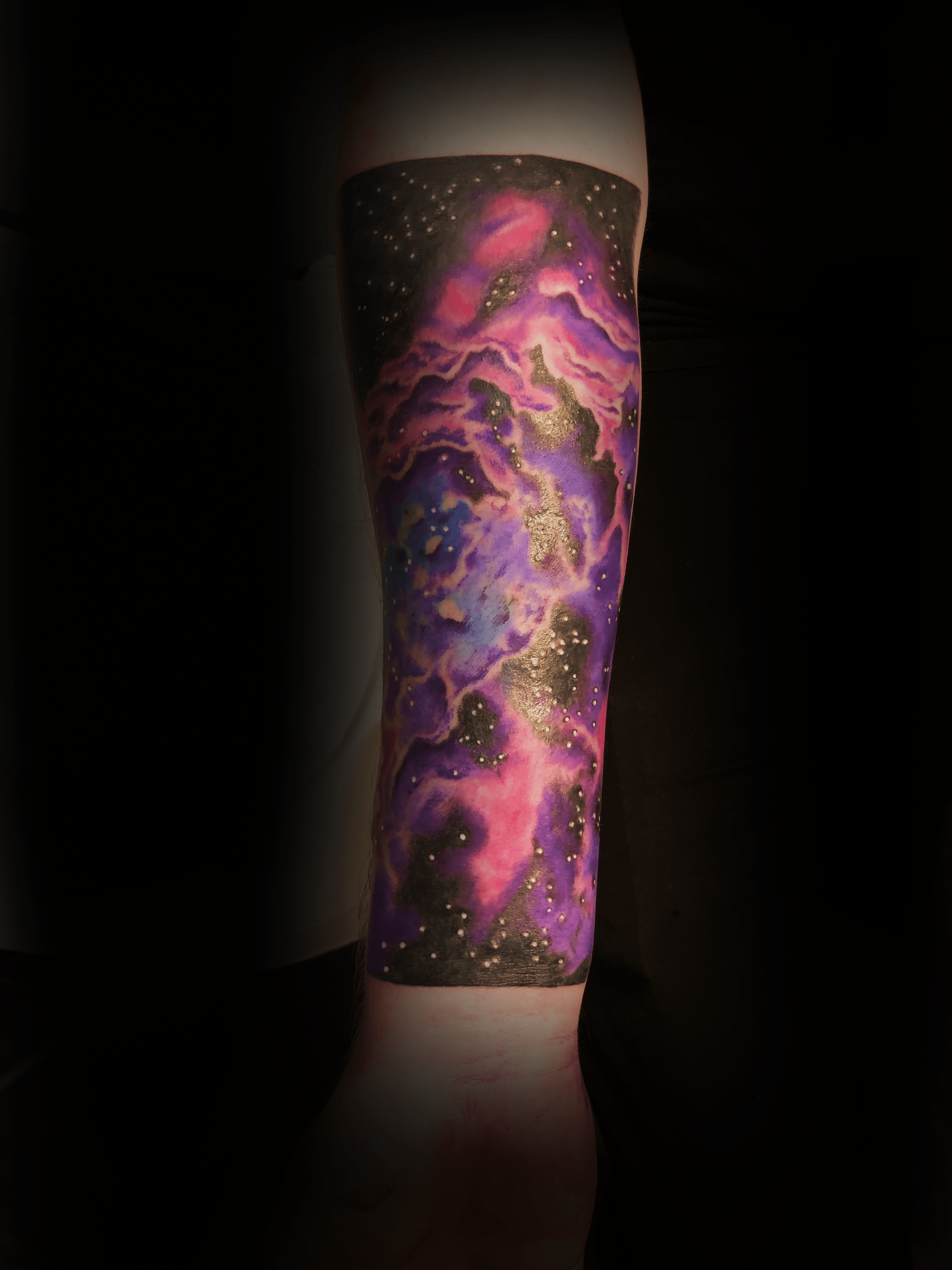 An image of a custom tattoo from Kevin Younger's Lucky Cat Tattoo Parlour: a design featuring a colourful galaxy nebula